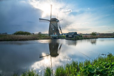 Kinderdijk 'te günbatımında parlayan geleneksel Hollanda rüzgar gülü 