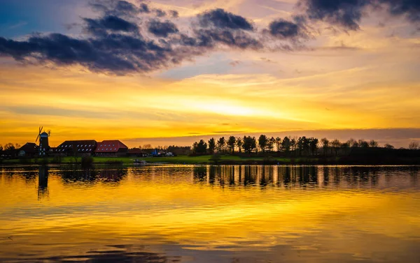 Milton Keynes 'deki Caldecotte Gölü yakınlarındaki eski yel değirmeninin günbatımı manzarası. İngiltere