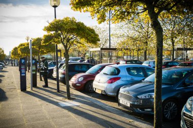 MILTON KEYNES, UK-OCTOBER 20, 2017: Milton Keynes şehir merkezindeki otopark görevlisi bilet makinesini kontrol ediyor