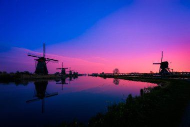 Kinderdijk 'teki geleneksel Hollanda yel değirmenlerinin silueti. Hollanda 
