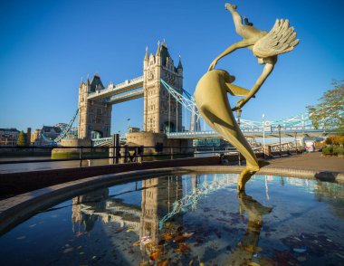 Kule Köprüsü ve St katharine Londra'da rıhtımında Yunus ile oynayan bir kız heykeli