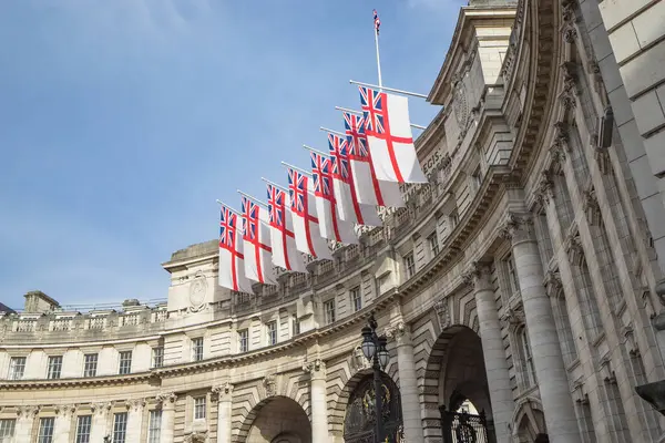 İngiliz bayrakları Trafalgar Meydanı 'nın yakınındaki deniz kuvvetleri bayrağında dalgalanıyor. Bulutlu mavi gökyüzü, Londra, Birleşik Krallık
