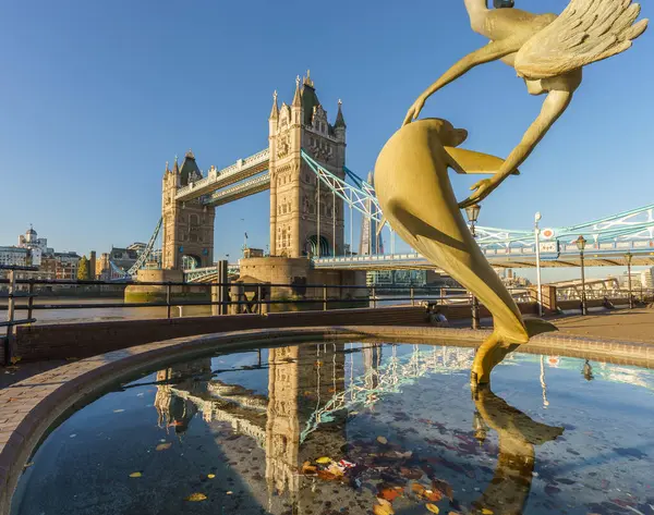 Kule Köprüsü ve St katharine Londra'da rıhtımında Yunus ile oynayan bir kız heykeli