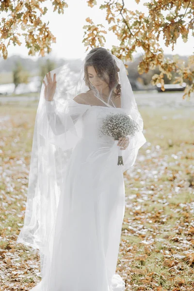 Noiva Bonita Elegante Sob Véu Fica Frente Olha Para Buquê — Fotografia de Stock