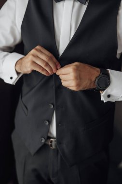 Şık damat elbiselerini giyer, düğün törenine hazırlanır. Damadın sabahı. İş adamı ceket giyiyor, erkek eli kapalı, damat düğün töreninden önce hazırlanıyor.