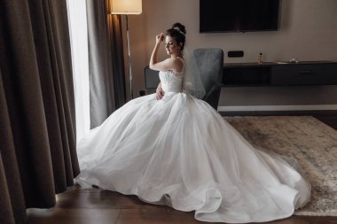 Gelinin sabahı. Gelini yaklaşan düğüne hazırlıyorum. Gelin beyaz gelinliğini gösteriyor..