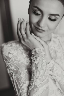 Güzel bir gelin, şık bir düğün saç stili, çıplak bir düğün makyajı. Genç ve güzel gelinin portresi gözlerini kapatıyor, düğün sabahı odada poz veriyor. Yüksek kalite fotoğraf