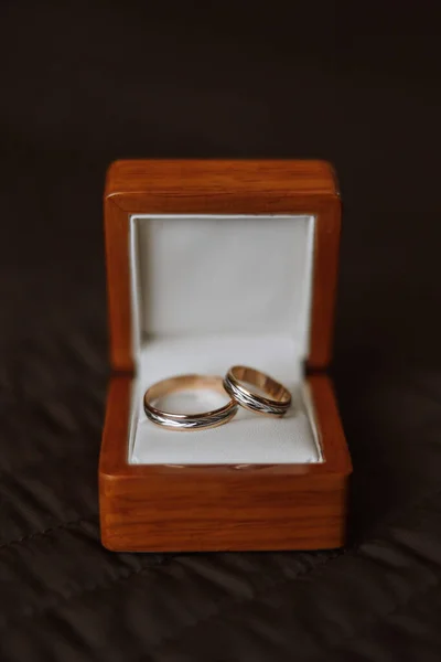 テーブルの上にボックス内の結婚指輪のクローズアップ 結婚指輪だ 柔らかい枕の上に木製の箱の中に2つの黄金の結婚指輪 — ストック写真