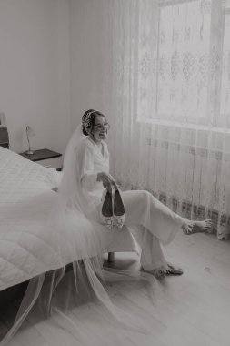 Düğünden önce gelinin sabahı. Beyaz cüppeli uzun peçeli güzel bir kadın. Doğal güzellik ve profesyonel makyaj. Beyaz dantel elbiseli kız..