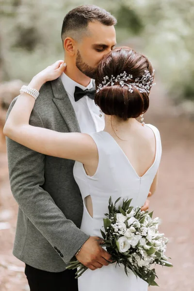 Sposo Tiene Mazzo Fiori Abbraccia Sua Moglie Baciandole Tempio Sposa — Foto Stock