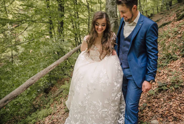 Cuplu Fericit Nunți Aleargă Lungul Unei Căi Forestiere Mireasa Zâmbeşte — Fotografie, imagine de stoc