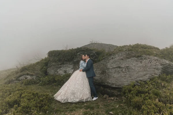 Ευτυχισμένο Ζευγάρι Στα Βουνά Κοντά Μια Μεγάλη Πέτρα Γαμπρός Φιλάει — Φωτογραφία Αρχείου