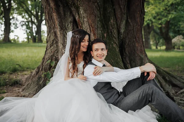 Şık Elbiseli Uzun Kıvırcık Saçlı Güzel Bir Gelin Damadı Kucaklıyor — Stok fotoğraf