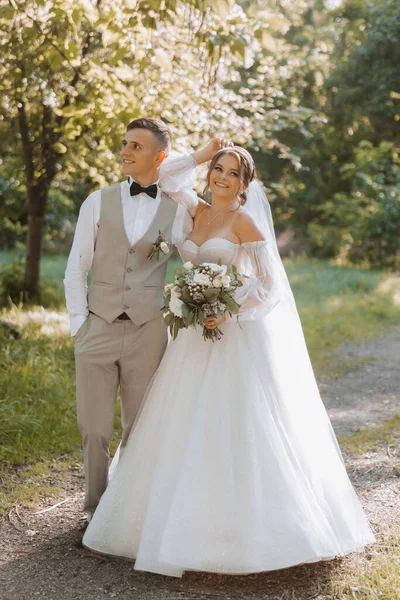 결혼식 사랑에 아름다운 커플의 공원을 산책하면서 과푸른 초목을 수있습니다 입맞춤 — 스톡 사진