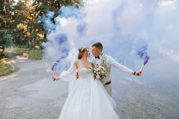 Ich Rękach Nowożeńcy Trzymają Wielobarwne Bomby Dymne Kolorze Niebieskim Pocałunek — Zdjęcie stockowe