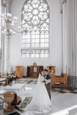 Lviv. Burası büyük bir Katolik kilisesi, şehrin ana merkezi. Parlak kilisenin içi, geniş kolonlardan oluşan bir manzara. Düğün törenindeki gelin ve damat, arkadan çekilen fotoğraf.