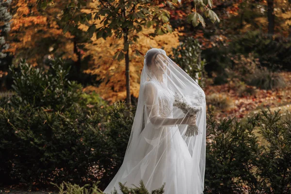 Mooie Bruid Met Gesloten Ogen Staand Een Herfstpark Haar Boeket — Stockfoto