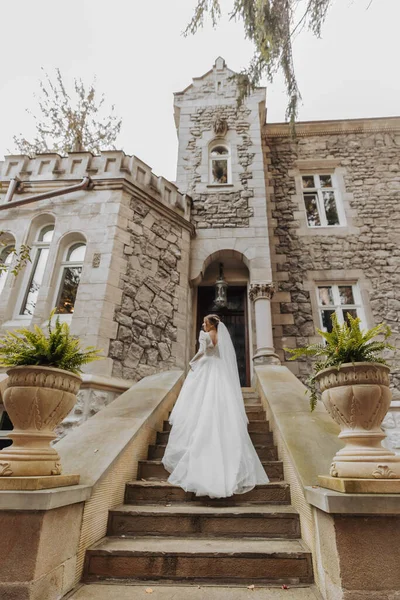 Zadní Pohled Nevěsty Bílých Elegantních Šatech Procházky Starém Zámku Venku — Stock fotografie