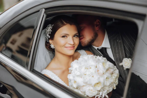 一个穿着花边衣服的新郎新娘坐在车窗里 美丽和微笑的新婚夫妇 节日快乐 — 图库照片