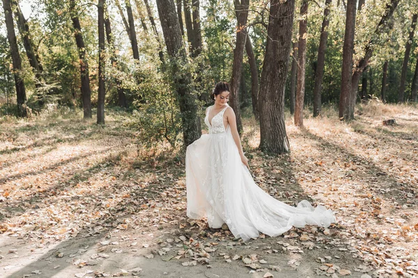 Noiva Vestido Branco Com Trem Longo Está Andando Floresta Olhando — Fotografia de Stock
