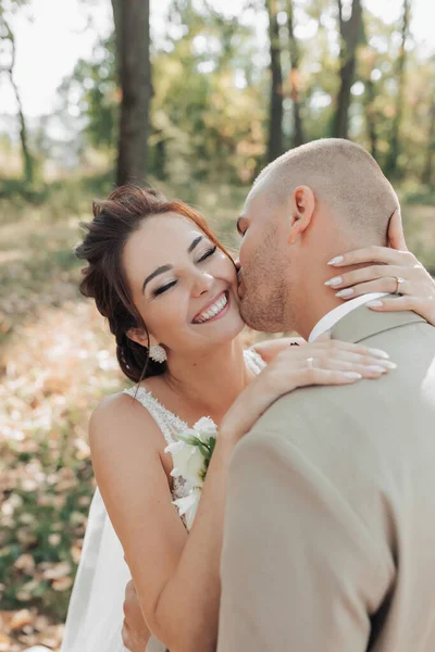 Esküvői Fotó Menyasszony Vőlegény Erdőben Állnak Ölelkezve Vőlegény Arcon Csókolja — Stock Fotó
