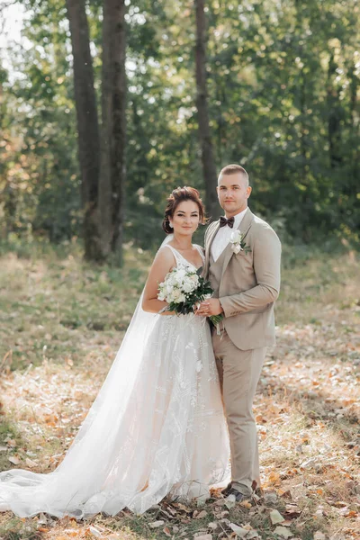 Γαμήλιο Πορτρέτο Νύφη Και Γαμπρός Στέκονται Στο Δάσος Αγκαλιασμένοι Και — Φωτογραφία Αρχείου
