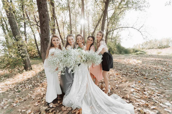 自然の中で結婚式の写真 花嫁と新婦付添人たちは森の中に立って 花束を持ってカメラのレンズを覗き込んでいる 幸せな結婚式のコンセプト 感情だ 女の子 — ストック写真