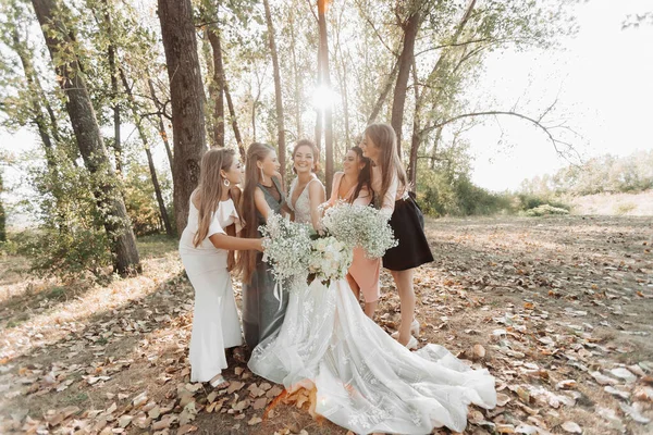 自然の中で結婚式の写真 花嫁と新婦付添人たちは 森の中に立って 花束を持って花嫁を見ています 幸せな結婚式のコンセプト 感情だ 女の子 — ストック写真