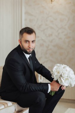 Erkek modası, erkek aksesuarları, iş adamı kıyafetleri, erkek tarzı, işadamı tarzı, iş adamı, Amerikalı, Avrupalı işadamı, insanlar, iş dünyası, moda ve giysi konsepti, elinde bir buket beyaz çiçek var.