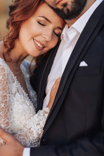 結婚式の肖像画 白いドレスの赤い髪の花嫁は 彼女の新郎に対して傾いている 美しいカールだ 誠実な笑顔 エレガントなドレス 髭の男 — ストック写真