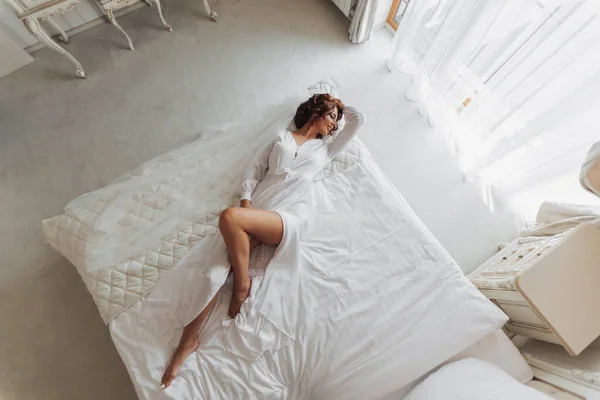 Bela Noiva Jovem Peignoir Branco Deitado Cama Quarto Hotel Preparativos — Fotografia de Stock
