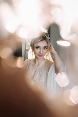 Sarışın gelin gelinlik ve tacın içinde poz veriyor, düğün portresi. Camların yansımaları ve yansımaları. Bir ışık anahtarında düğün fotoğrafı