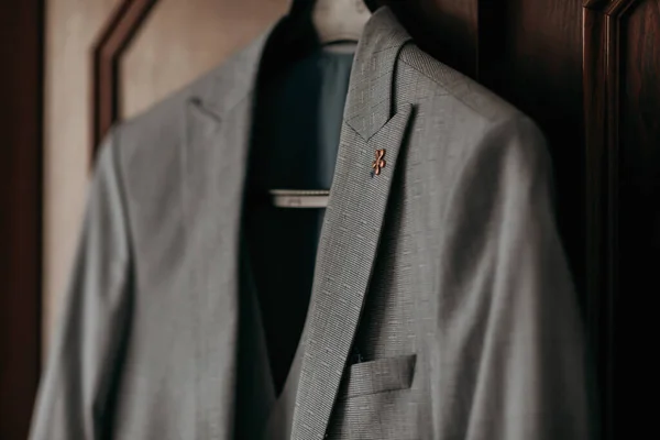一件灰色时髦的夹克挂在棕色的背景上 男人的风格 时尚和商业 — 图库照片