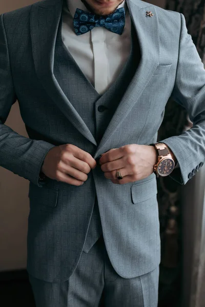 スタイリッシュな男がジャケットを調整してる写真だ 正面図 スタイリッシュな時計です 男性のスタイル ファッションだ — ストック写真