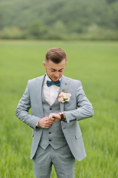 Portrait Groom Standing Background Green Field Looking His Watch Stylish — Stock Photo, Image