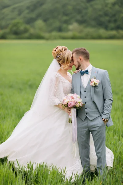 Recém Casados Ficam Campo Verde Beijam Noiva Está Segurar Buquê — Fotografia de Stock