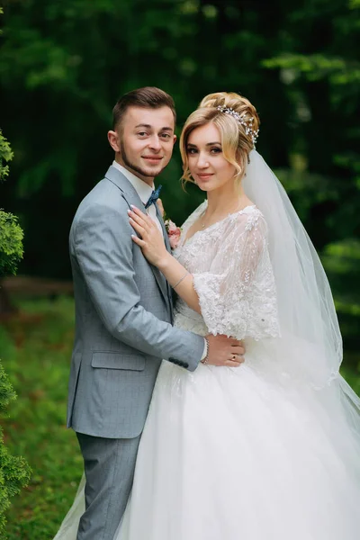 Menyasszony Vőlegény Portréja Amint Zöld Fák Hátterében Állnak Ölelkeznek Lencsébe — Stock Fotó