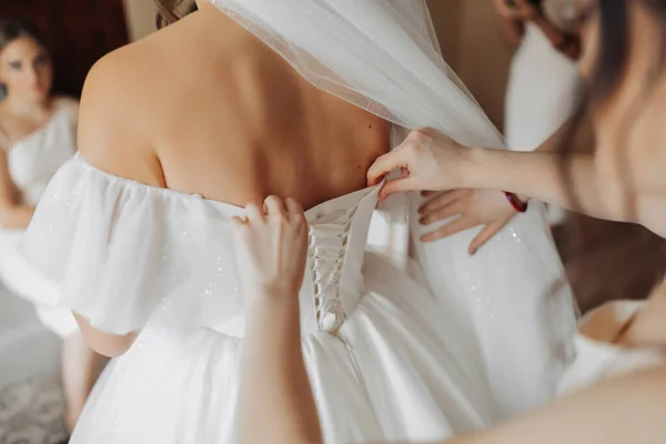 Przyjaciele Panny Młodej Zapinają Białą Obszerną Suknię Panny Młodej Widok — Zdjęcie stockowe