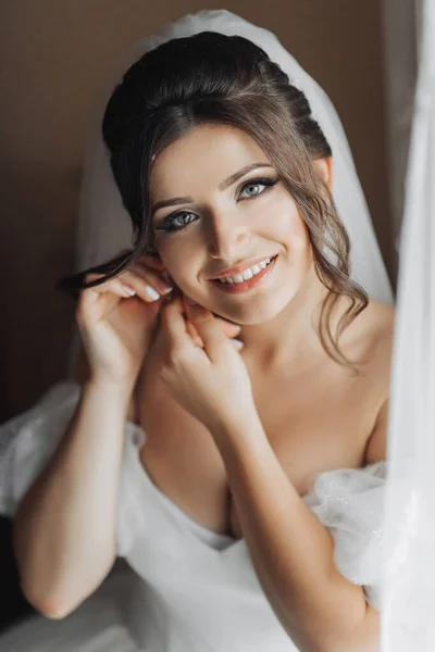 Brunette Bride White Dress Puts Her Earrings Smiles Sincerely Camera — Stock Photo, Image