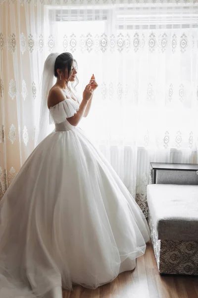 Eine Brünette Braut Einem Weißen Kleid Posiert Fenster Und Faltet — Stockfoto