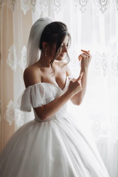 Uma Noiva Morena Vestido Branco Posando Junto Janela Belamente Dobrando — Fotografia de Stock