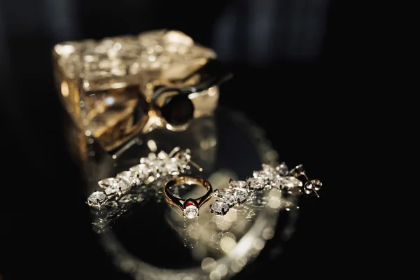 Bröllopsfoton Parfym Och Eleganta Silverörhängen Och Brudens Vigselring Ett Glasbord — Stockfoto
