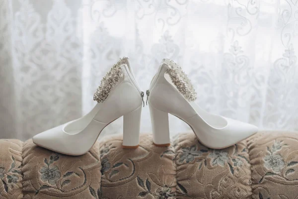Fotografie Detailů Svatbě Bílé Elegantní Boty Dekorací Noze Stojící Pohovce — Stock fotografie