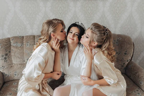 Egy Barna Menyasszony Szőke Barátai Ülnek Kanapén Menyasszony Szobájában Fürdőköpenyben — Stock Fotó