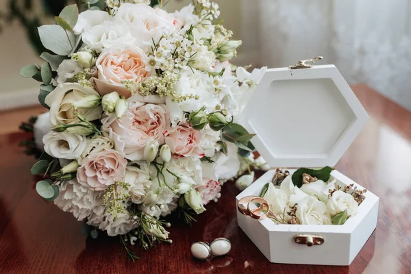 婚礼附件的照片 新郎华丽的花束 金戒指在一个有花的架子上 白色袖扣在木制地板的底座上 — 图库照片