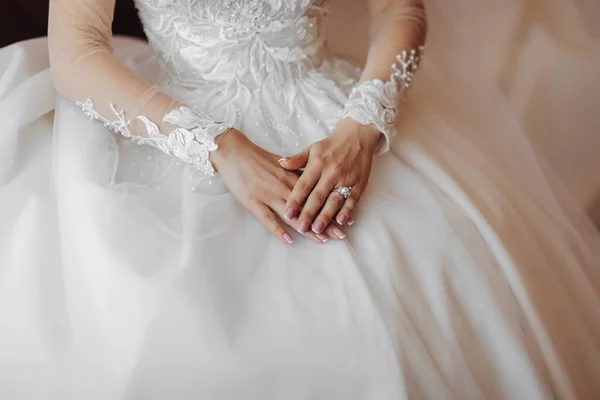 stock image Cropped photo. Beautiful hands with a lace sleeve on a white wedding dress. Wedding portrait. French manicure