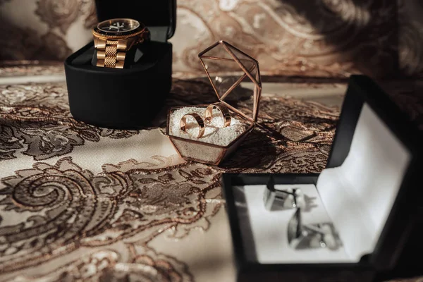 新郎の結婚式のためのアクセサリー 金の時計 金のリング 黄金のテーブルクロスに銀のカフスボタン 男性のファッションとスタイル — ストック写真