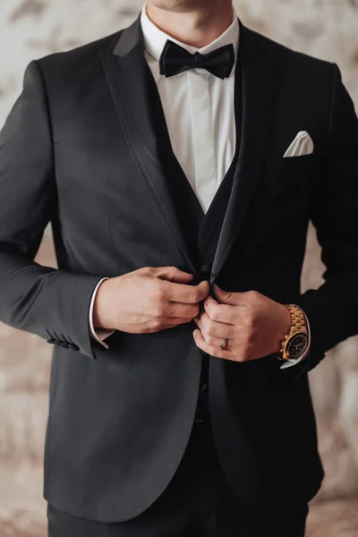 スタイリッシュな男がジャケットを調整してる写真だ 正面図 スタイリッシュな時計です 男性のスタイル ファッションだ — ストック写真