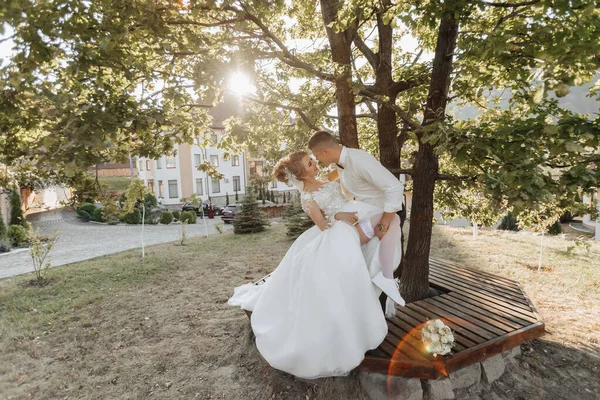 Huwelijksportret Bruidegom Een Zwart Pak Blonde Bruid Staan Zoenen Onder — Stockfoto