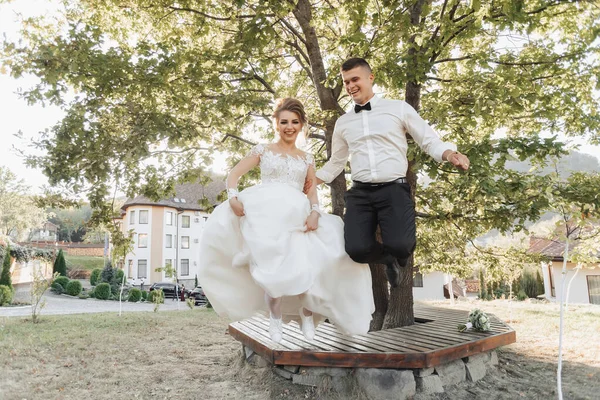 Retrato Casamento Noivo Terno Preto Noiva Loira Vestido Sapatilhas Saltam — Fotografia de Stock